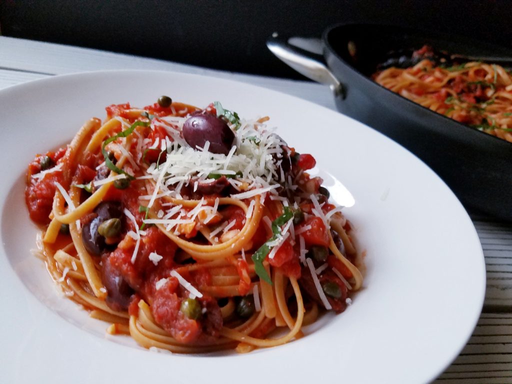 pasta puttanesca with cheese on top